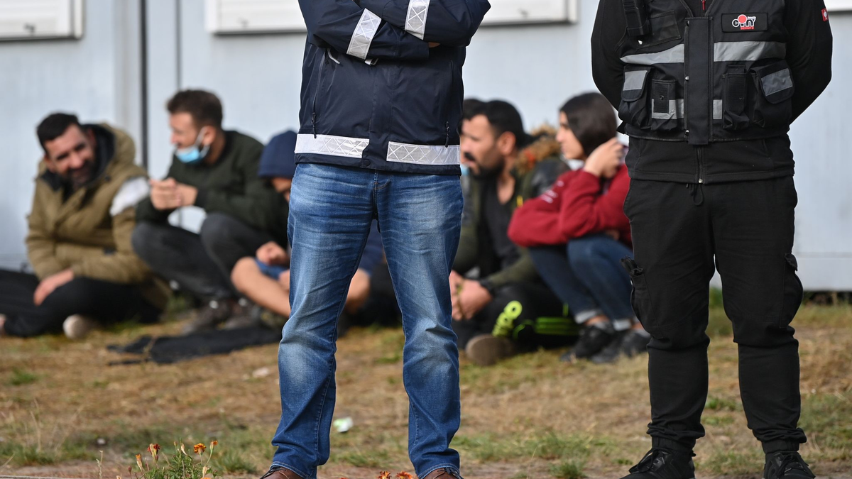 Wachpersonal steht vor der Zentralen Erstaufnahmeeinrichtung für Asylbewerber (ZABH) des Landes Brandenburg in Eisenhüttenstadt. - Foto: Patrick Pleul/dpa-Zentralbild/dpa