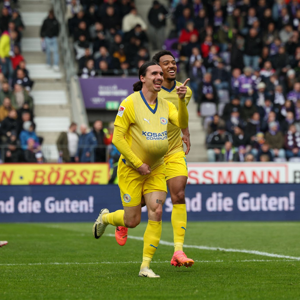 Der Braunschweiger Torschütze Rayan Philippe (M.) feierte seinen Treffer mit dem Ball unter dem Trikot. - Foto: Friso Gentsch/dpa