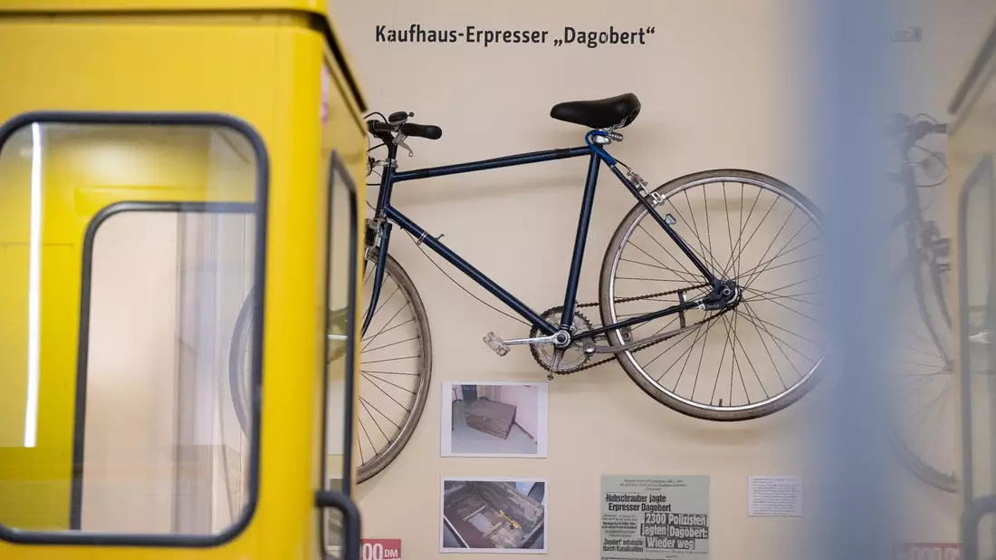 Eine Telefonzelle und Ausstellungsstücke wie das Fahrrad von Kaufhaus-Erpresser Dagobert in der Polizeihistorischen Sammlung der Polizei Berlin. - Bild: Sebastian Gollnow/dpa