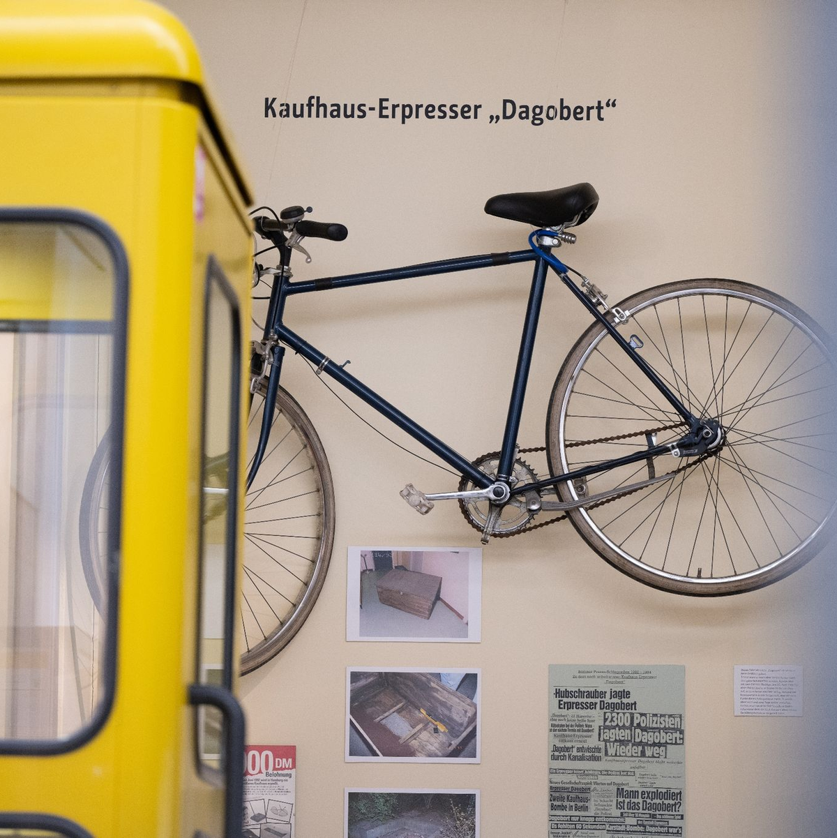 Eine Telefonzelle und Ausstellungsstücke wie das Fahrrad von Kaufhaus-Erpresser Dagobert in der Polizeihistorischen Sammlung der Polizei Berlin. - Foto: Sebastian Gollnow/dpa