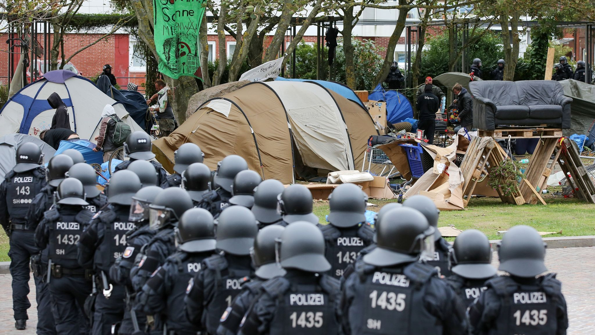 Behelmte Polizisten 2022 bei der freiwilligen Räumung des Punk-Protestcamps auf Sylt. - Foto: Bodo Marks/dpa