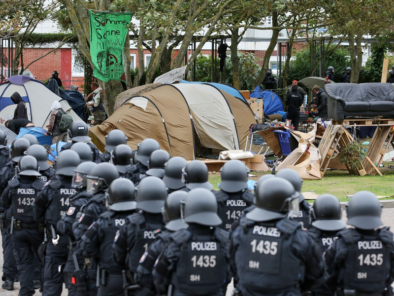 Behelmte Polizisten 2022 bei der freiwilligen RĂ€umung des Punk-Protestcamps auf Sylt. - Foto: Bodo Marks/dpa