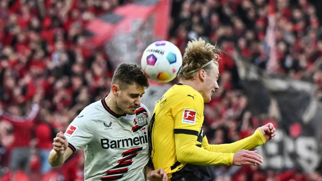 Leverkusens Josip Stanisic und Dortmunds Julian Brandt kämpfen um den Ball. - Bild: Federico Gambarini/dpa