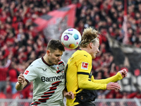 Leverkusens Josip Stanisic und Dortmunds Julian Brandt kämpfen um den Ball. - Foto: Federico Gambarini/dpa