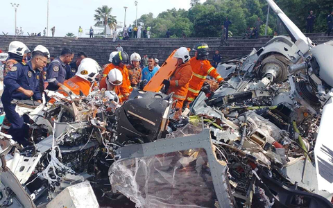 Rettungsdienst und Feuerwehr inspizieren die Absturzstelle. - Foto: Terence Tan/Fire & Rescue Department of Malaysia/AP/dpa