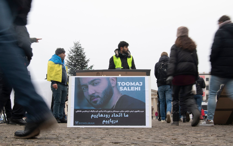 Protestaktion gegen Irans Staatsführung auf dem Pariser Platz in Berlin. Auf dem Plakat ist der Rapper Salehi zu sehen. - Foto: Paul Zinken/dpa