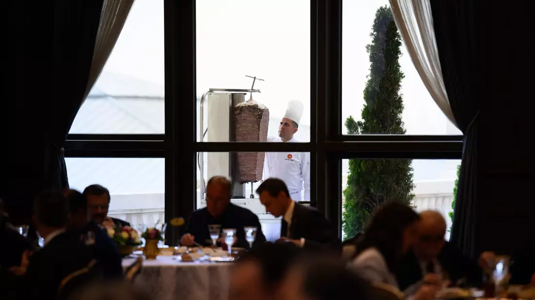 Ein Koch bereitet auf einer Terrasse des Präsidialpalasts Dönerfleisch vom Spieß zu. - Bild: Bernd von Jutrczenka/dpa
