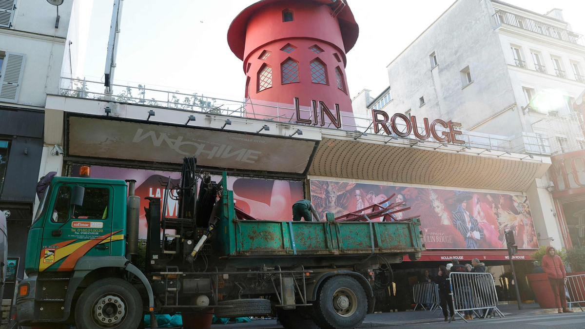 Arbeiter sichern den Bereich vor dem Kabarett, nachdem die Flügel des Windrads des «Moulin Rouge» in der Nacht abgestürzt sind. - Foto: Geoffroy Van Der Hasselt/AFP/dpa