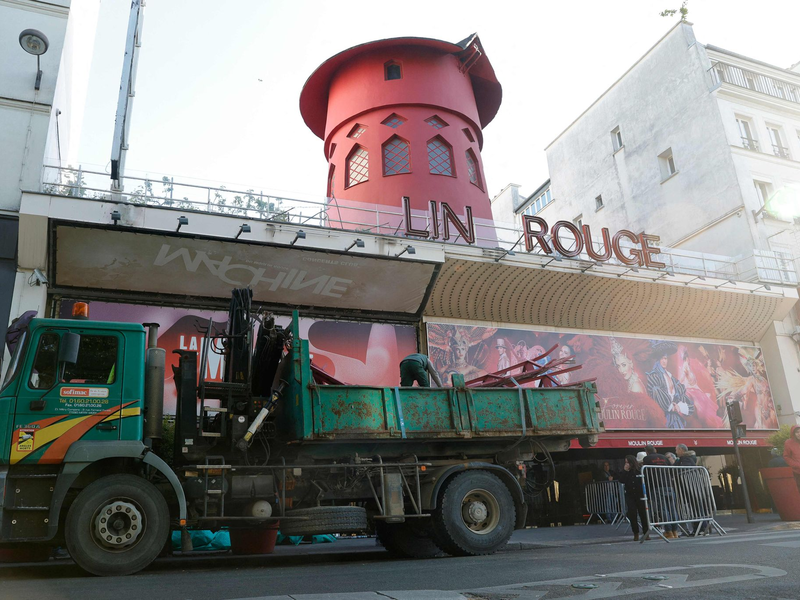 Arbeiter sichern den Bereich vor dem Kabarett, nachdem die Flügel des Windrads des «Moulin Rouge» in der Nacht abgestürzt sind. - Foto: Geoffroy Van Der Hasselt/AFP/dpa