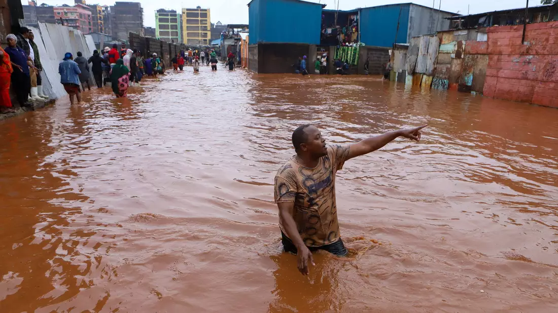 Ein Mann watet in Nairobi durch das Hochwasser. - Bild: Joy Nabukewa/XinHua/dpa