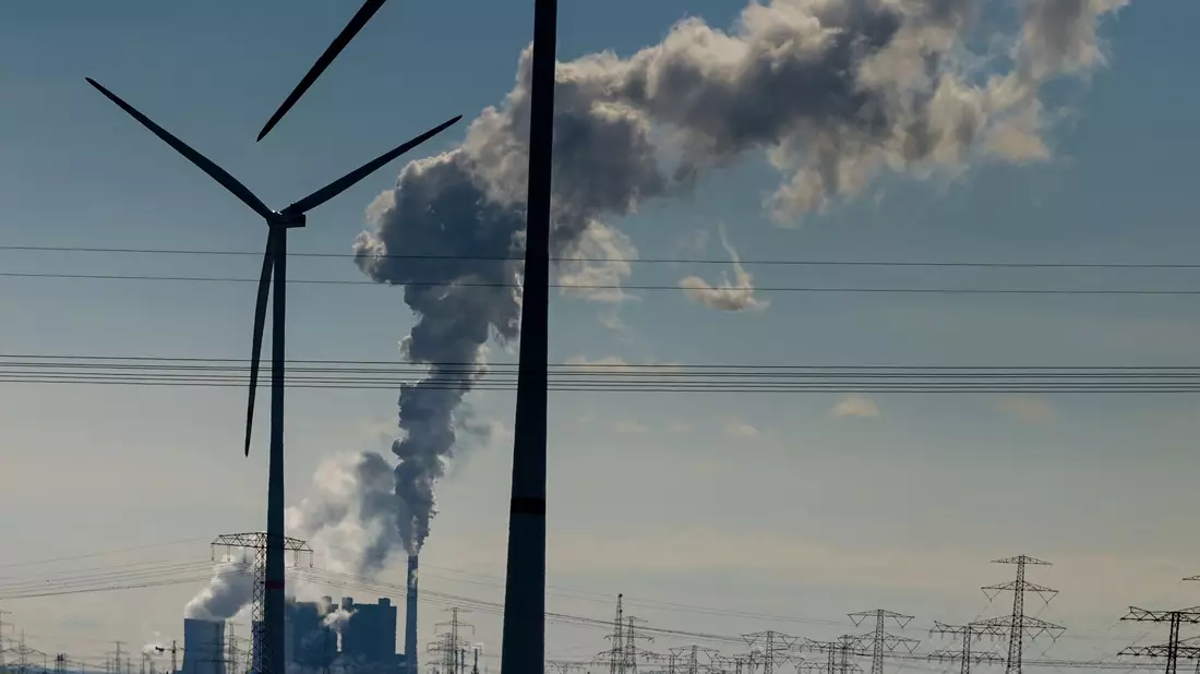 Windräder im Energiepark Bad Lauchstädt, eine Stromtrasse und qualmende Schornsteine in einem Industriegebiet. - Bild: Heiko Rebsch/dpa