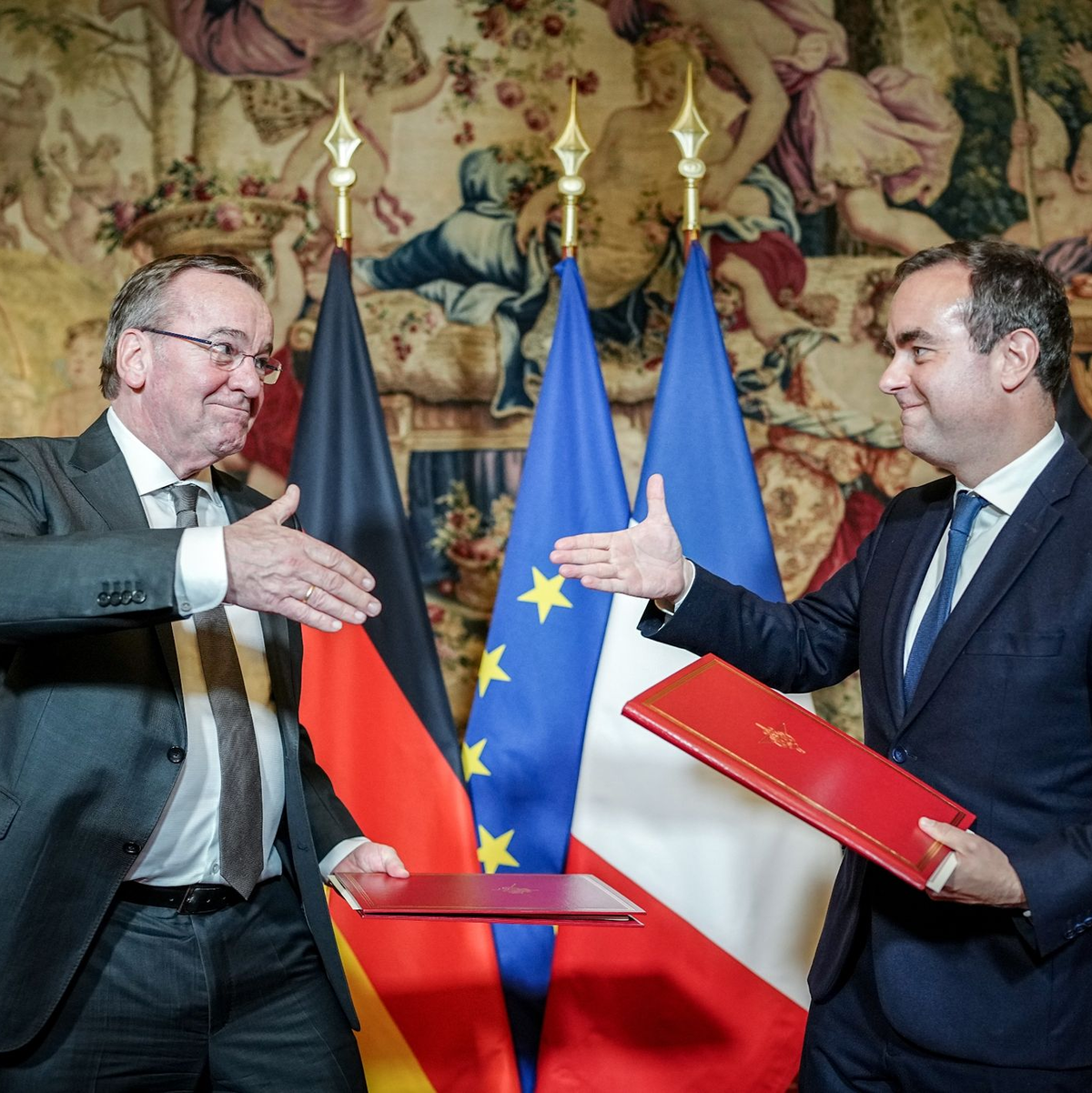 Boris Pistorius (l) und Sébastien Lecornu geben sich nach der Unterzeichnung der Absichtserklärung beider Länder für das Kampfpanzersystem der Zukunft die Hand. - Foto: Kay Nietfeld/dpa