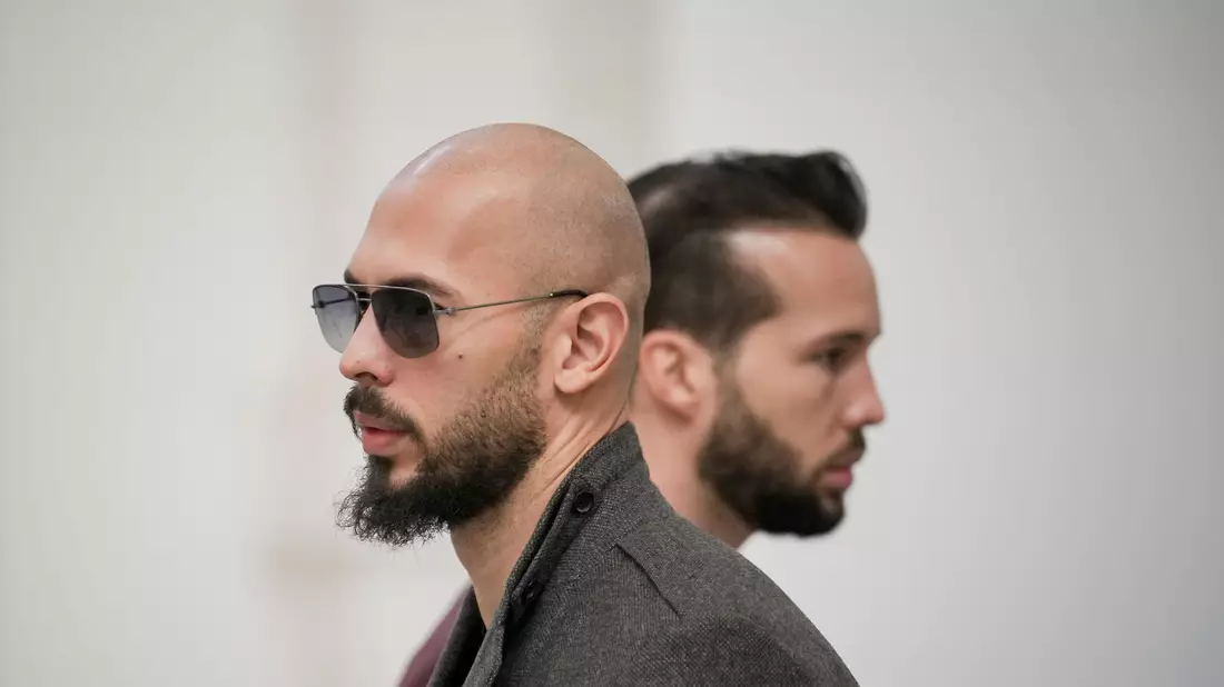 Andrew Tate (l) und sein Bruder Tristan warten im Gebäude des Berufungsgerichts in Bukarest. Den beiden Brüdern wird vorgeworfen, junge Frauen sexuell ausgebeutet zu haben. - Bild: Vadim Ghirda/AP/dpa