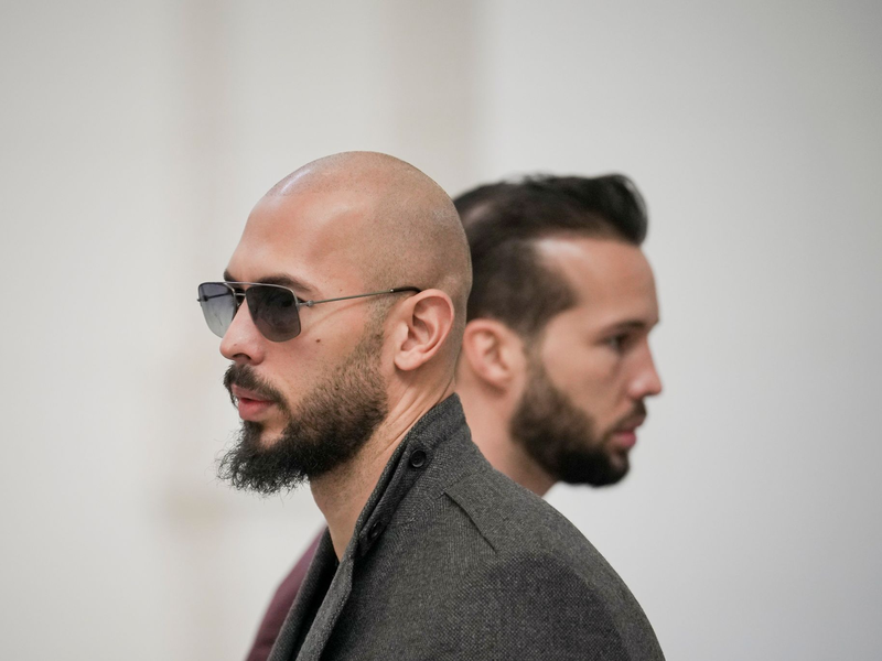 Andrew Tate (l) und sein Bruder Tristan warten im Gebäude des Berufungsgerichts in Bukarest. Den beiden Brüdern wird vorgeworfen, junge Frauen sexuell ausgebeutet zu haben. - Foto: Vadim Ghirda/AP/dpa