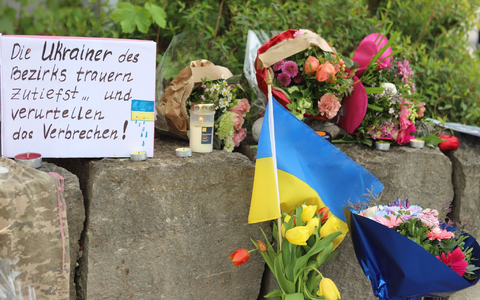 Am Gelände eines Einkaufszentrums, an dem zwei Männer aus der Ukraine getötet worden sind, wurden Blumen niedergelegt sowie eine kleine ukrainische Flagge aufgestellt. - Foto: Constanze Wilz/dpa