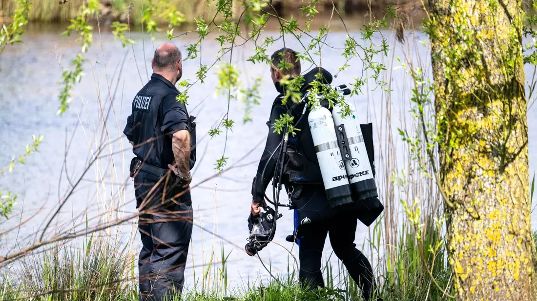 Ein Taucher der Polizei steigt in die Oste. - Bild: Sina Schuldt/dpa