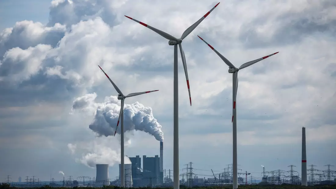 Windräder drehen sich vor der Kulisse des Braunkohlekraftwerks Schkopau westlich von Halle (Saale). - Bild: Jan Woitas/dpa