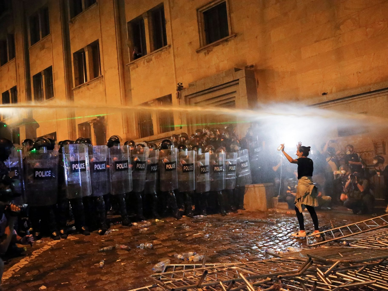 Eine Demonstrantin steht in Tiflis Bereitschaftspolizisten gegenüber. - Foto: Zurab Tsertsvadze/AP/dpa