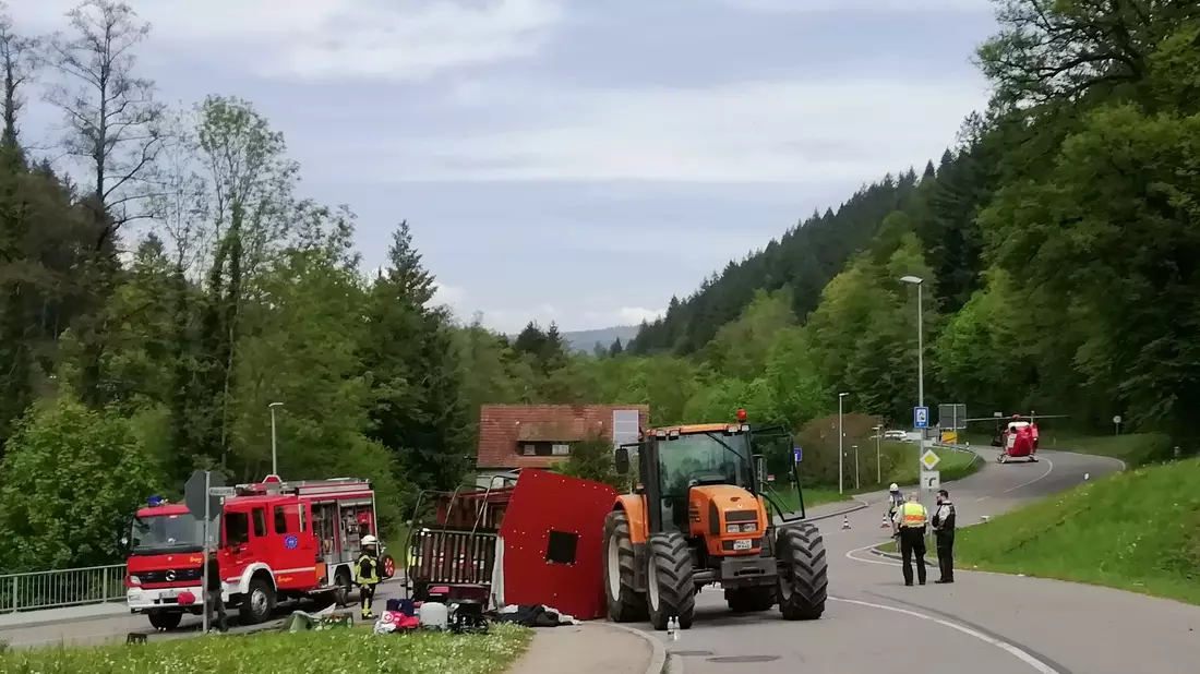 Unfall mit Maiwagen: Rettungskräfte neben dem umgestürzten Maiwagen in Kandern. - Bild: Gudrun Gehr/Oberbadisches Verlagshaus/dpa