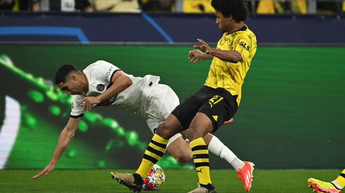 BVB-Flügelspieler Karim Adeyemi (r) bringt den Ex-Dortmunder Achraf Hakimi zu Fall. - Bild: Federico Gambarini/dpa
