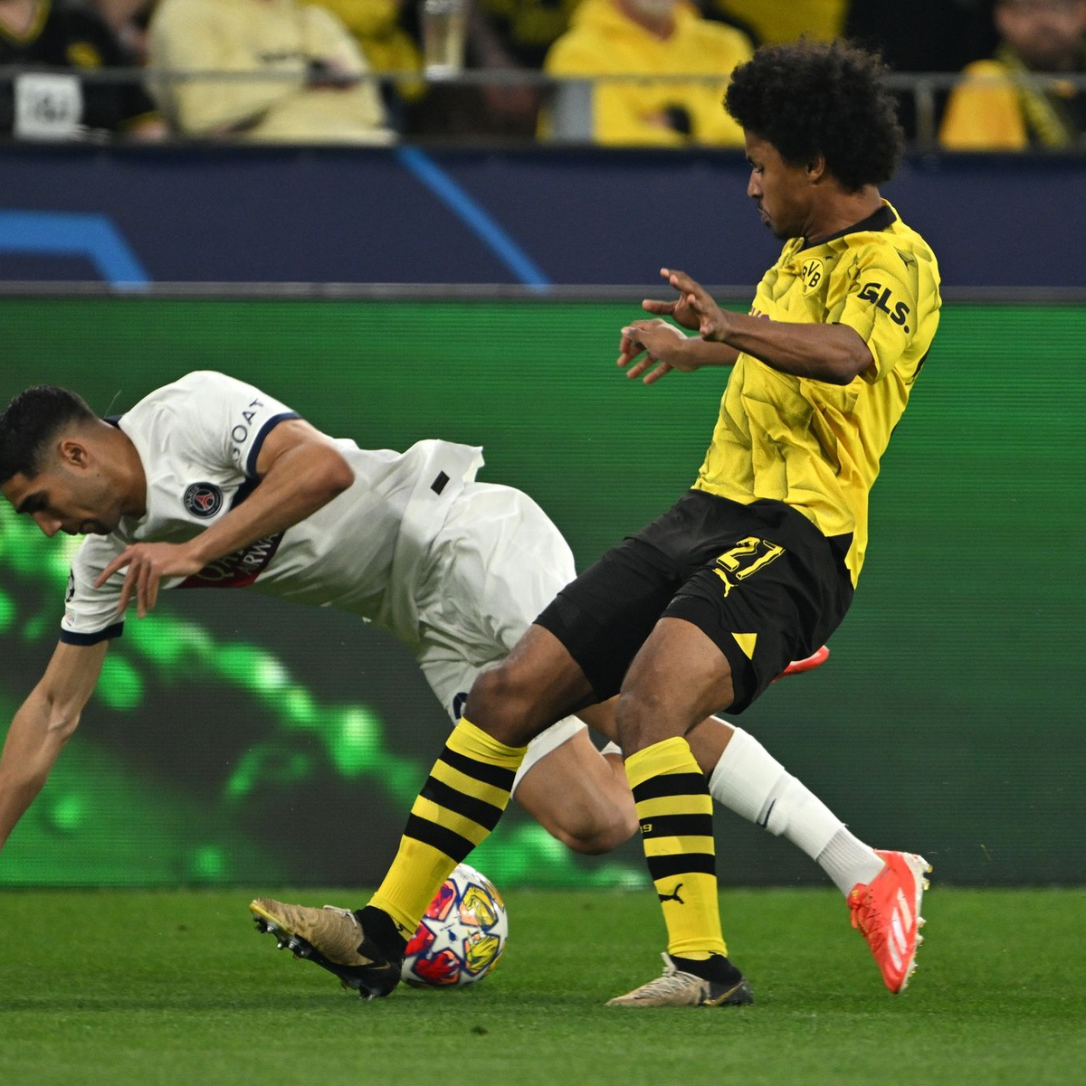 BVB-Flügelspieler Karim Adeyemi (r) bringt den Ex-Dortmunder Achraf Hakimi zu Fall. - Foto: Federico Gambarini/dpa