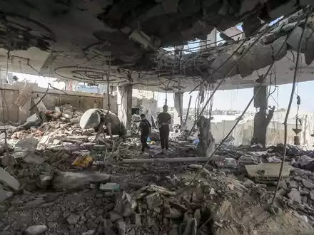 Palästinenser stehen in den Trümmern eines Hauses nach einem israelischen Luftangriff, bei dem mehrere Menschen getötet wurden. - Foto: Ismael Abu Dayyah/AP/dpa