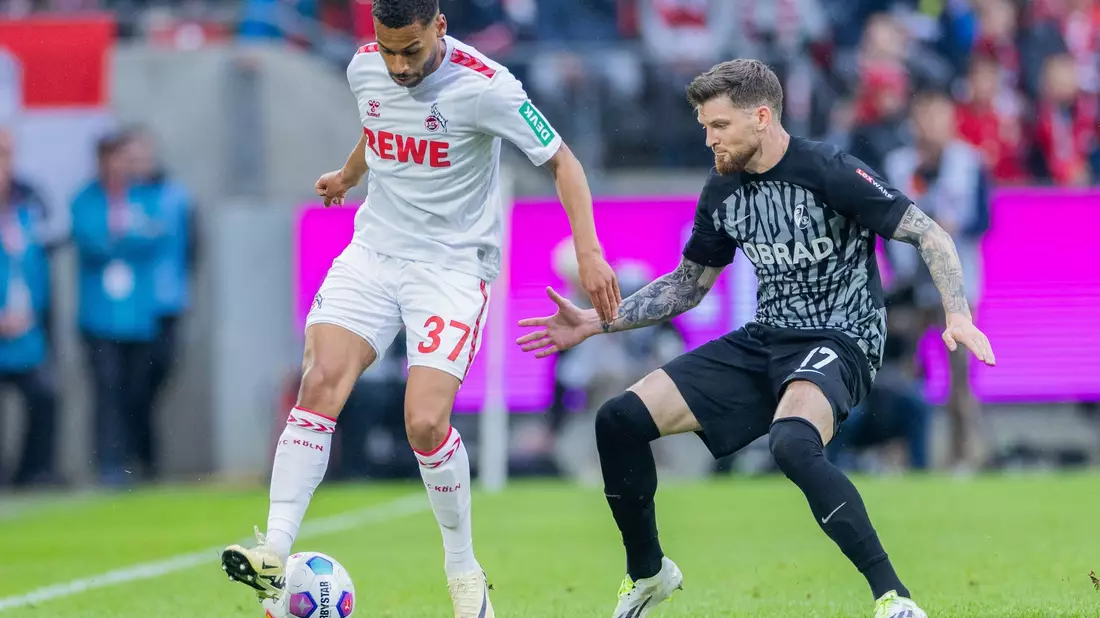 Kölns Linton Maina (l) im Zweikampf mit dem Freiburger Lukas Kübler. - Bild: Rolf Vennenbernd/dpa