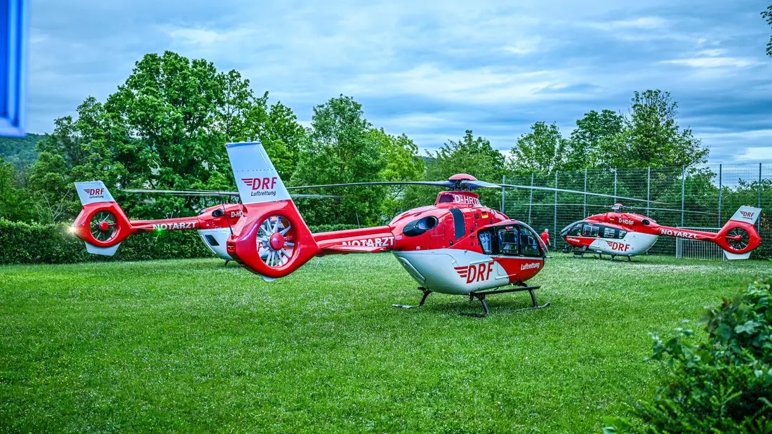 Rettungshubschrauber stehen auf einer Wiese in der Nähe der Turnhalle in Remshalden. - Bild: Marius Bulling/dpa
