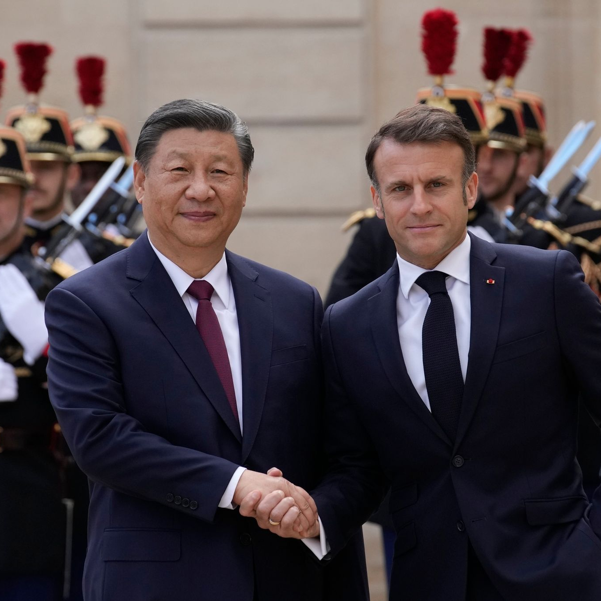 Der französische Präsident Emmanuel Macron (r) begrüßt Chinas Präsident Xi Jinping vor ihrem Treffen im Elysee-Palast. - Foto: Christophe Ena/AP/dpa