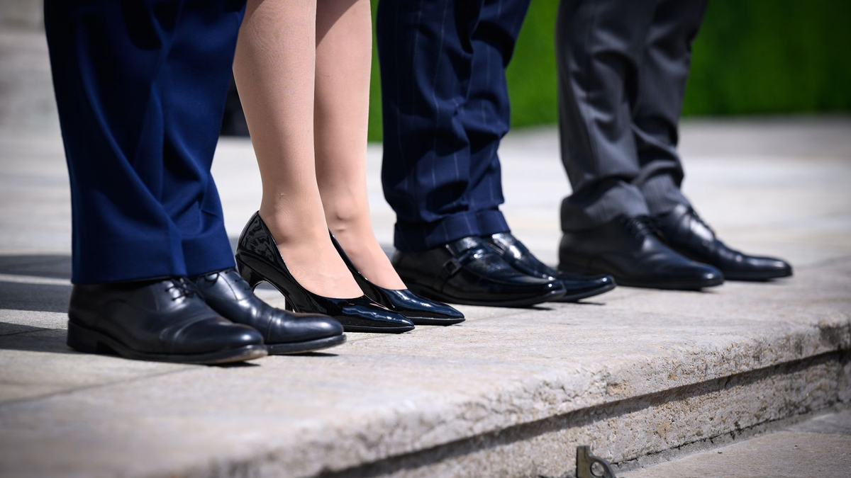 Eine Frau steht zwischen drei Männern in Anzügen auf den Treppenstufen von Schloss Bellevue. - Foto: Bernd von Jutrczenka/dpa