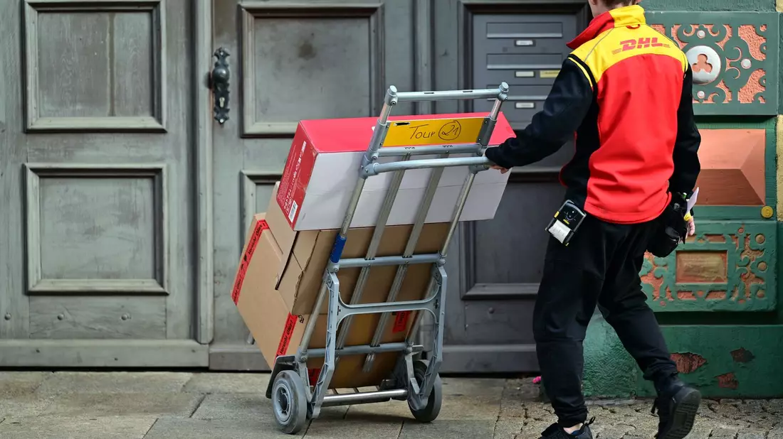 Klassische Briefe gibt es immer seltener. Doch dank des Online-Handels profitiert die Deutsche Post vom Paketversand. - Bild: Martin Schutt/dpa