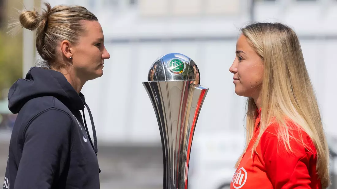 Alexandra Popp (l) vom VfL Wolfsburg und Giulia Gwinn vom FC Bayern München und der DFB-Pokal. - Bild: Rolf Vennenbernd/dpa