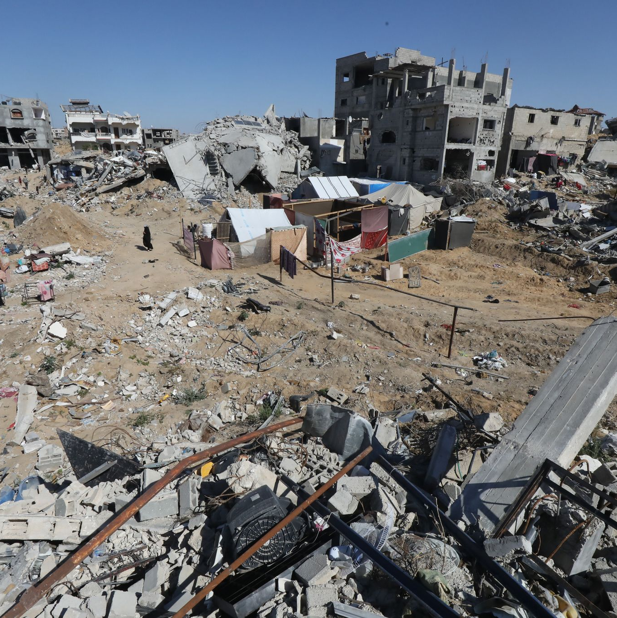 Umgeben von Trümmern gehen diese Palästinenser durch das zerstörte Chan Junis. - Foto: Omar Naaman/dpa