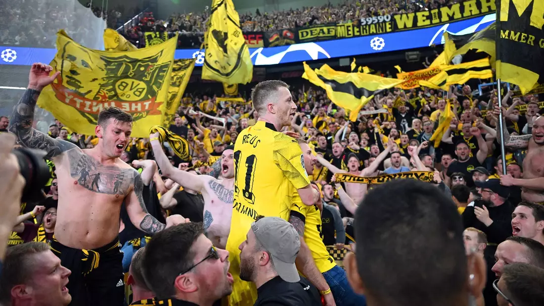 Dortmunds Marco Reus (M) jubelt mit den mitgereisten Fans über den Sieg bei Paris Saint-Germain. - Bild: Robert Michael/dpa