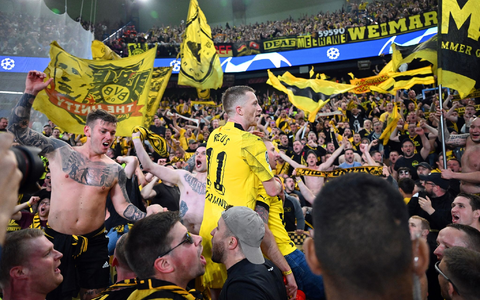 Dortmunds Marco Reus (M) jubelt mit den mitgereisten Fans über den Sieg bei Paris Saint-Germain. - Foto: Robert Michael/dpa