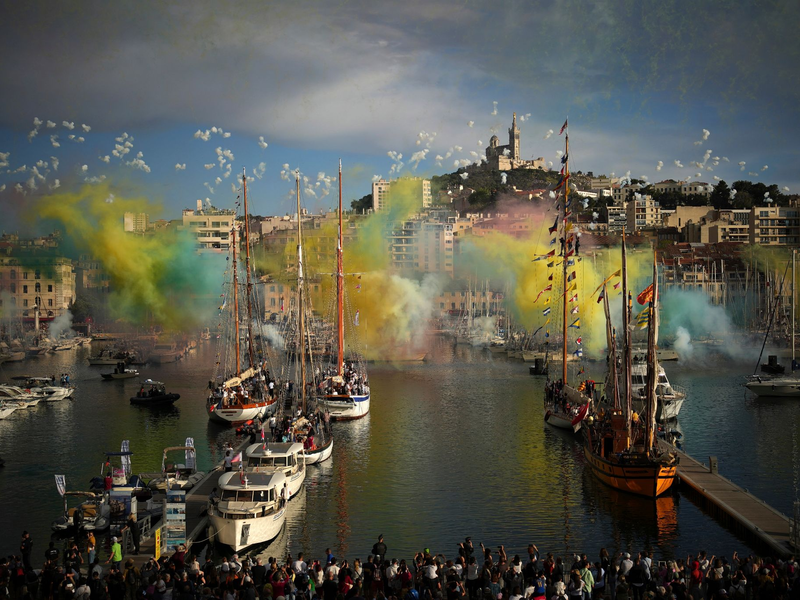Ein Feuerwerk wurde gezündet, als die olympische Flamme per Schiff in Marseille einlief. - Foto: Daniel Cole/AP/dpa