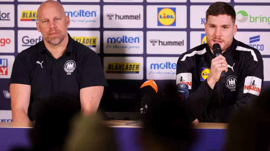 Axel Kromer (l) und Kapitän Johannes Golla sitzen während einer Pressekonferenz auf dem Podium. - Bild: Jan Woitas/dpa