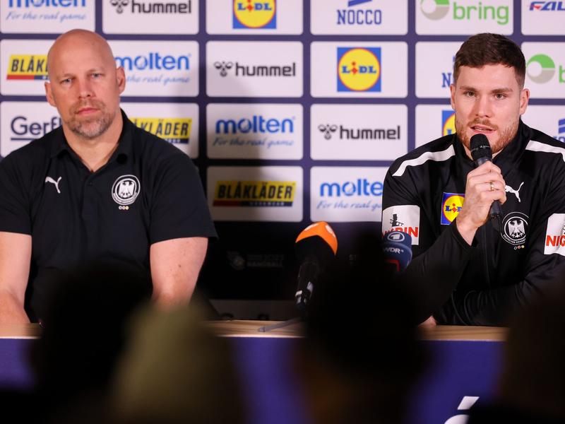 Axel Kromer (l) und Kapitän Johannes Golla sitzen während einer Pressekonferenz auf dem Podium. - Foto: Jan Woitas/dpa