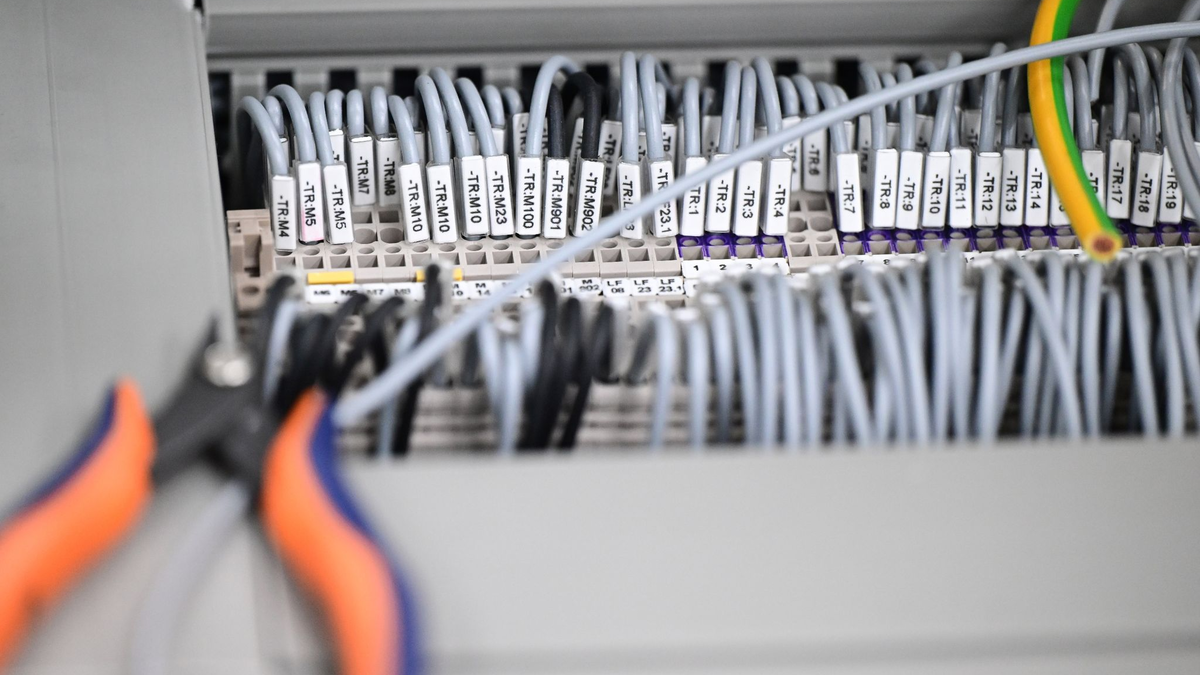 Kabelstränge liegen in einer Produktionshalle: Das Geschäftsklima in der deutschen Elektro- und Digitalindustrie ist zurückgefallen. - Foto: Bernd Weißbrod/dpa