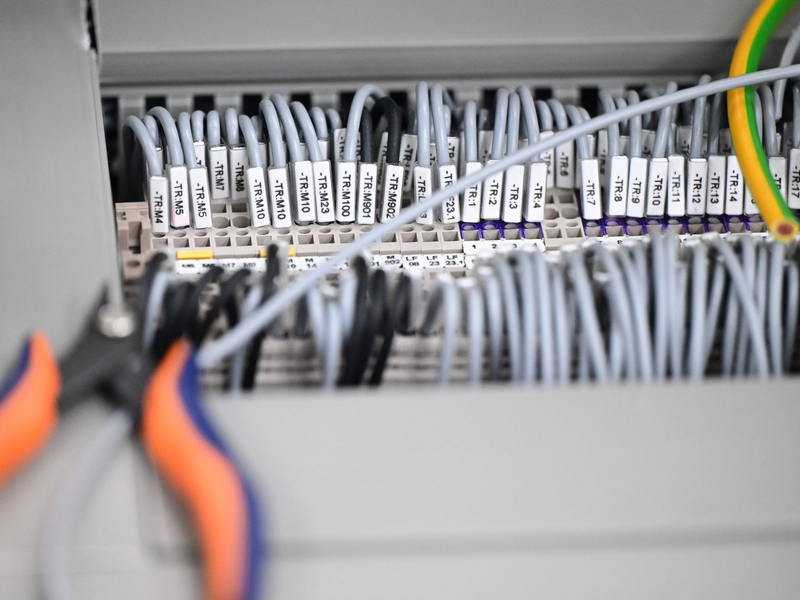 Kabelstränge liegen in einer Produktionshalle: Das Geschäftsklima in der deutschen Elektro- und Digitalindustrie ist zurückgefallen. - Foto: Bernd Weißbrod/dpa