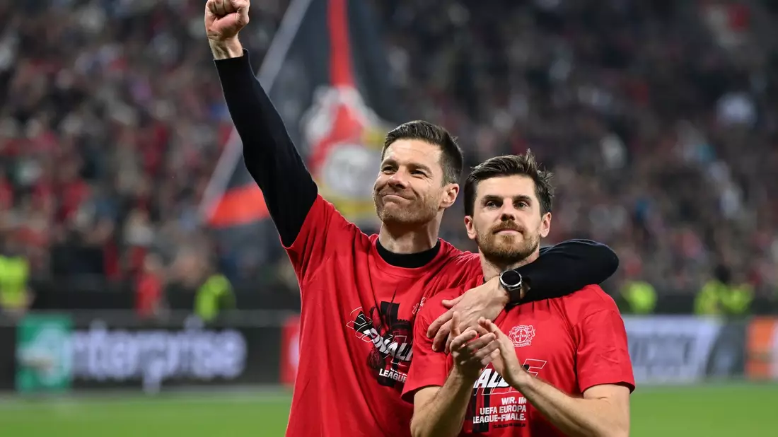 Leverkusens Trainer Xabi Alonso und Jonas Hofmann (r) feiern mit den Fans nach dem Spiel gegen Rom. - Bild: Federico Gambarini/dpa