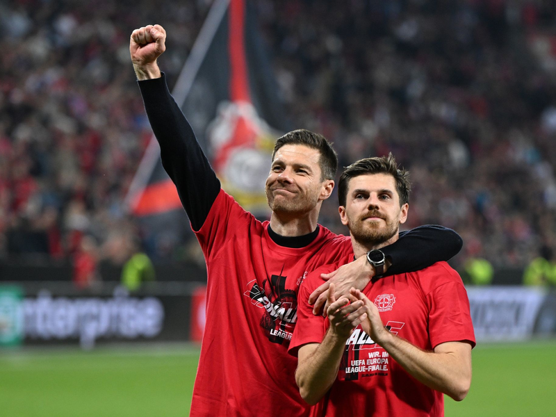 Leverkusens Trainer Xabi Alonso und Jonas Hofmann (r) feiern mit den Fans nach dem Spiel gegen Rom. - Foto: Federico Gambarini/dpa