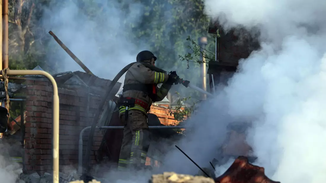 Nach einem russischen Angriff bei Charkiw versuchen ukrainische Rettungskräfte ein Feuer zu löschen. - Bild: Not credited/https://photonew.ukrinform.com/ Ukrinform/dpa