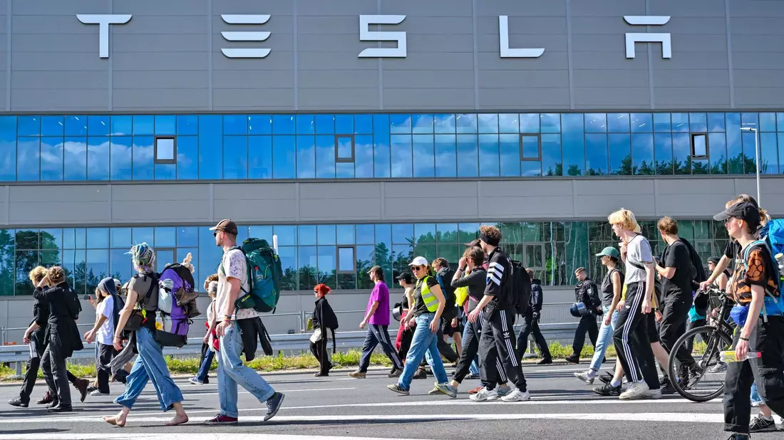Teilnehmer einer Protestveranstaltung gehen zum Werk von Tesla. - Bild: Patrick Pleul/dpa