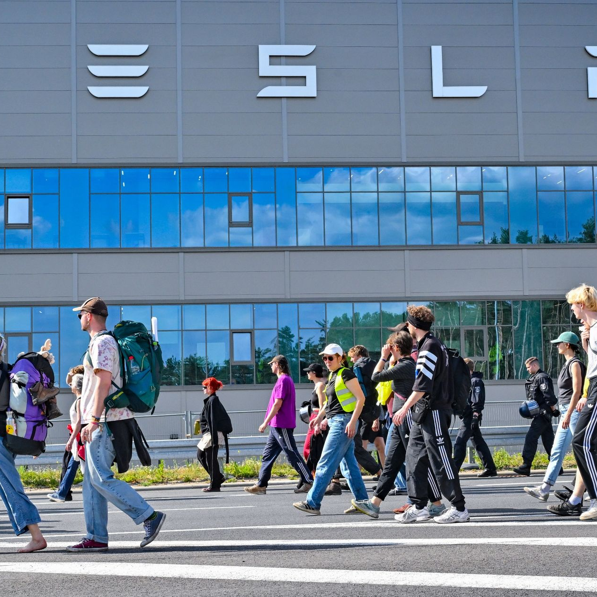 Teilnehmer einer Protestveranstaltung gehen zum Werk von Tesla. - Foto: Patrick Pleul/dpa