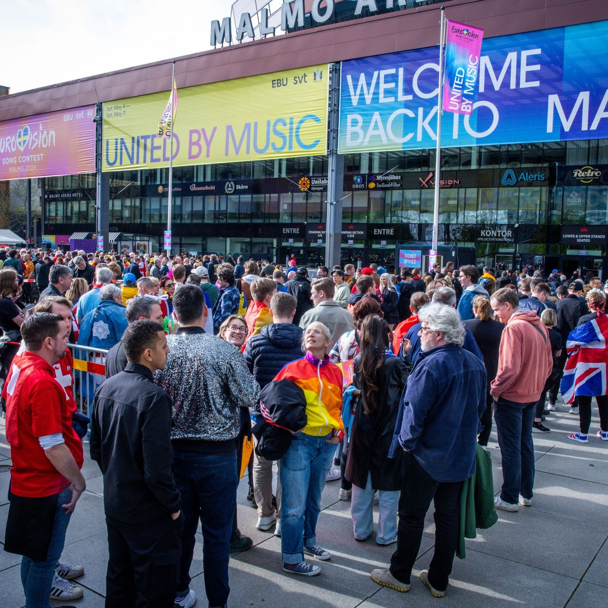 Musikfans stehen vor Beginn des Finales des Eurovision Song Contest 2024 vor der Malmö Arena. - Foto: Jens Büttner/dpa