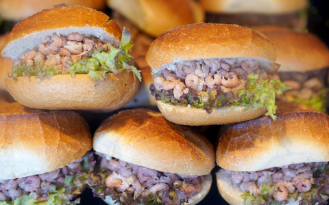 Brötchen mit Nordseekrabben in der Auslage eines Fischbrötchen-Imbisses an den Hamburger Landungsbrücken. - Foto: Marcus Brandt/dpa