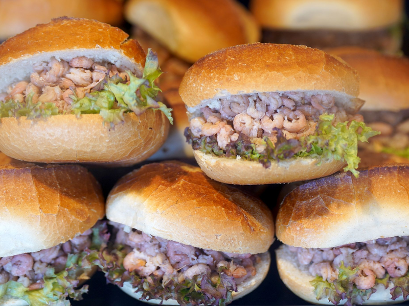 Brötchen mit Nordseekrabben in der Auslage eines Fischbrötchen-Imbisses an den Hamburger Landungsbrücken. - Foto: Marcus Brandt/dpa