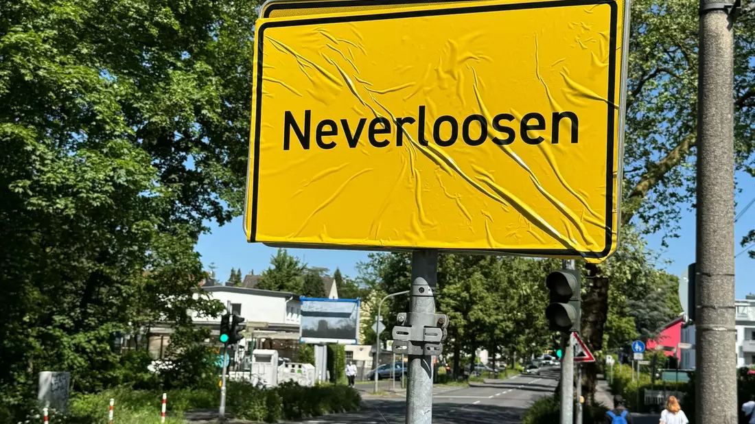 Das Ortsschild von Leverkusen im Stadtteil Schlebusch ist mit der Aufschrift «Neverloosen» überklebt worden. - Bild: Holger Schmidt/dpa