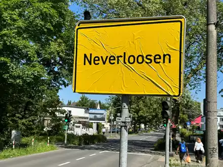 Das Ortsschild von Leverkusen im Stadtteil Schlebusch ist mit der Aufschrift «Neverloosen» überklebt worden. - Foto: Holger Schmidt/dpa